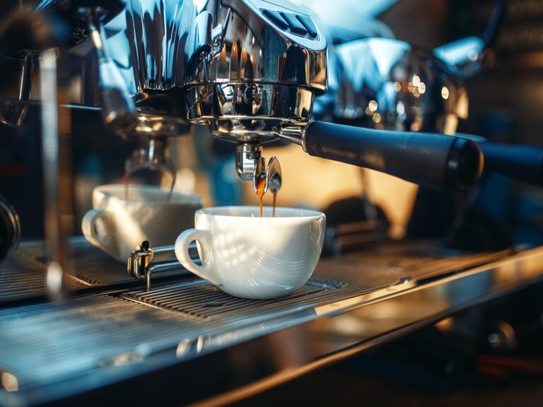 Espressomaschine, die frischen Kaffee in eine weiße Tasse laufen lässt